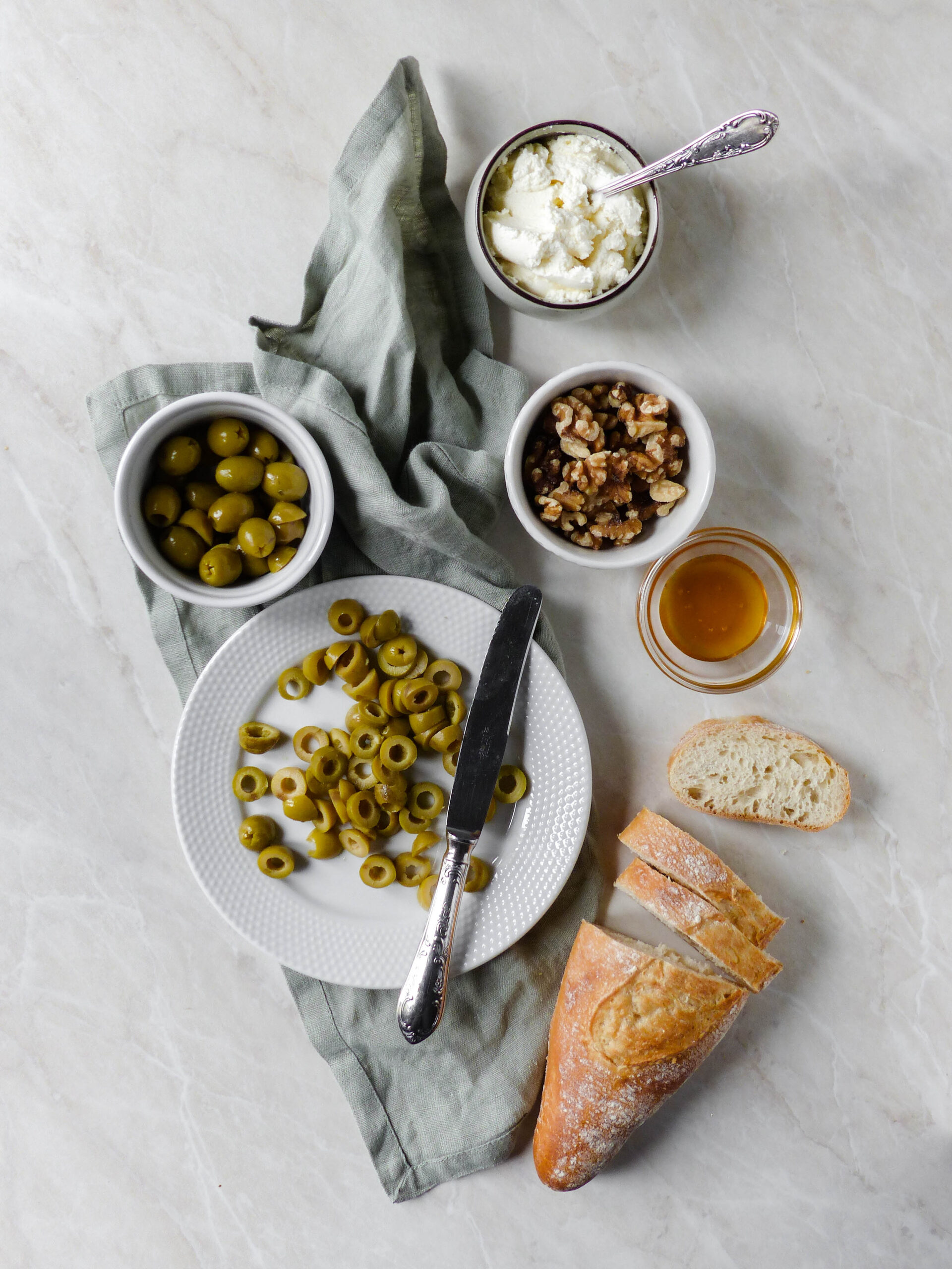 Crostini mit Frischkäse, marinierten Oliven, Walnüssen & Minze